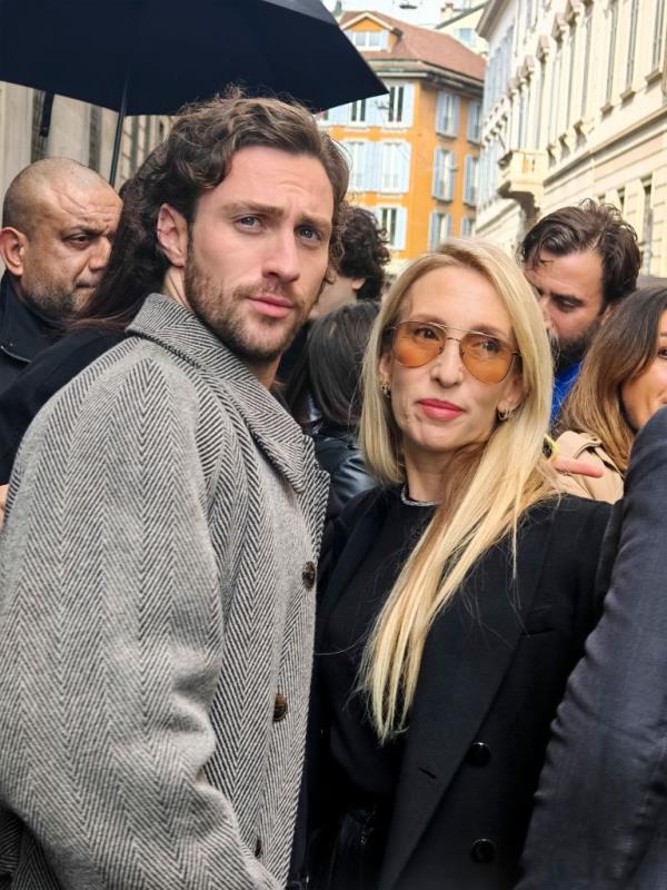 Aaron Taylor-Johnson and Sam Taylor-Johnson standing together at the outside arrivals for the Giorgio Armani show, Autumn Winter 2024, during Milan Fashion Week in Italy.