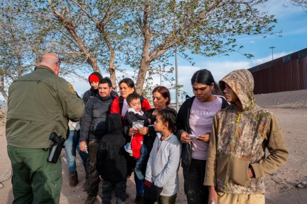 A group of migrants waiting to be processed by a Border Patrol officer near after crossing the Rio Grande near El Paso on April 2, 2024.