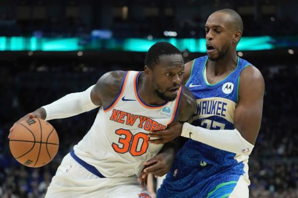 New York Knicks' Julius Randle tries to get past Milwaukee Bucks' Khris Middleton 