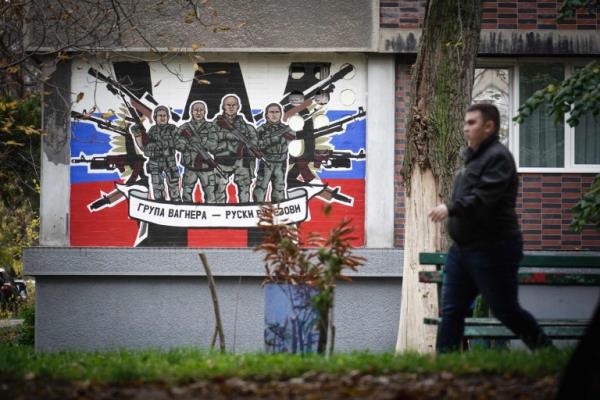 A pedestrian walks past a mural depicting Russia's para military mercenaries 'Wagner Group'