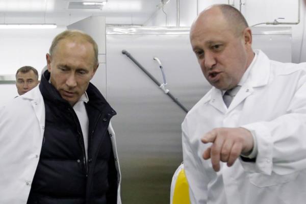 Yevgeny Prigozhin shows Russian Prime Minister Vladimir Putin his school lunch factory