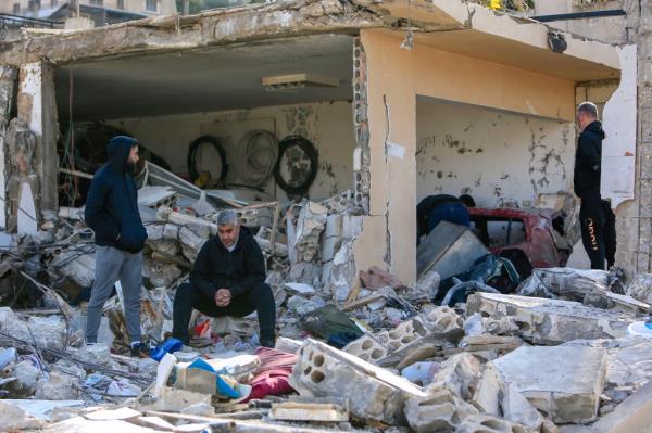 Men check the rubble of a building in Bint Jbeil in southern Lebanon near the border with Israel, following Israeli bombardment the previous night.