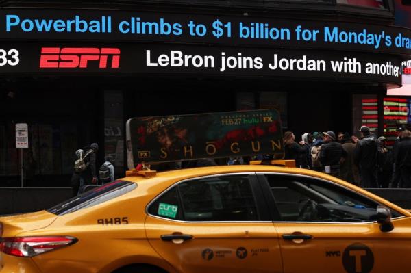 NYC cab in Times Square with a digital billboard behind it.