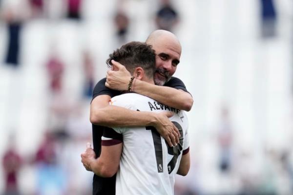 Manchester City's head coach Pep Guardiola celebrates with Manchester City's Julian Alvarez