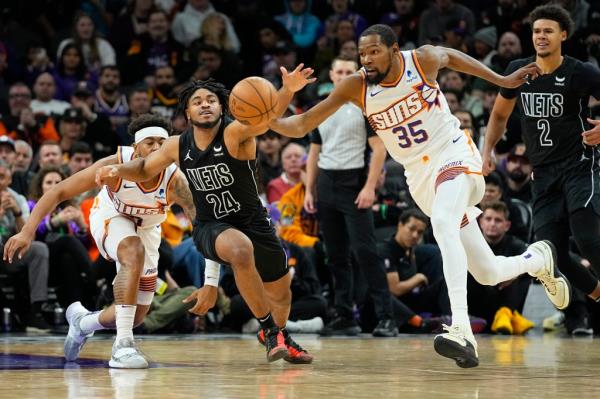 Brooklyn Nets guard Cam Thomas (24) and Phoenix Suns forward Kevin Durant (35) chase down a loose ball during the second half of an NBA basketball game, Wednesday, Dec. 13, 2023
