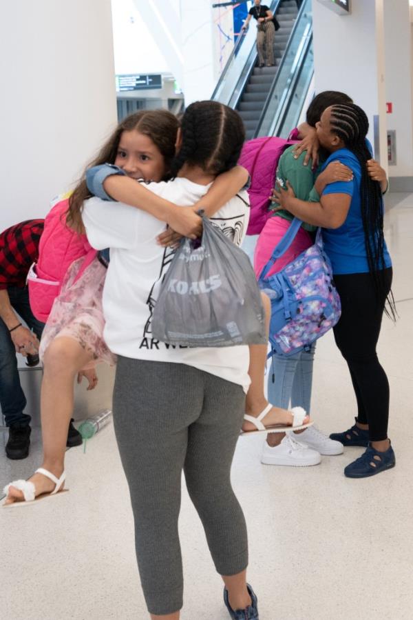 Paola Alvarez, center, hugs her little cousin, Isabella Villa Briseno, at LaGuardia Airport, while Paola's mom, Osleydy Alvarez, is in the background holding her other niece, Yugleydis Villa Alvarez. The family was separated at the US border.