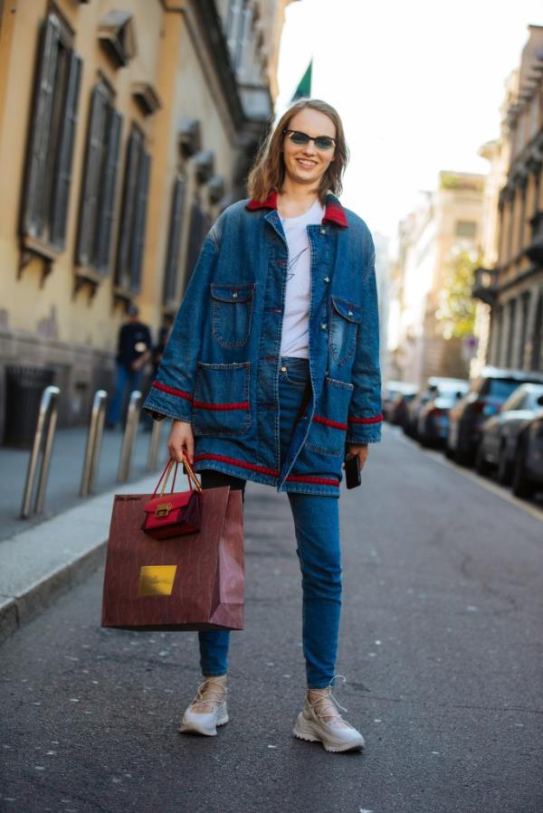 Model Fran Summers in Fendi sunglasses, an oversized denim jacket, white shirt, jeans, and white lace-up Coach ballet sneakers at Milan Fashion Week Autumn/Winter 2019/20