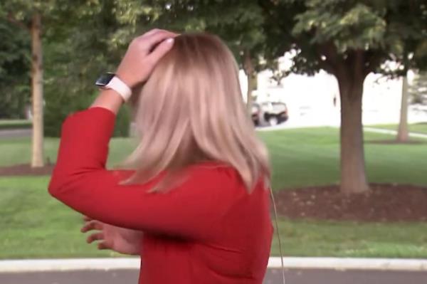 NewsNation reporter Kellie Meyer pats her had and turns to look.