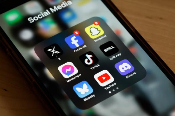 Phone displaying TikTok app in New York City with a proposed bill to ban the app for natio<em></em>nal security risk in the background.