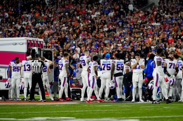 The Buffalo Bills gather as an ambulance parks on the field while CPR is administered to Buffalo Bills safety Damar Hamlin