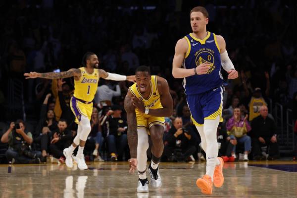Lo<em></em>nnie Walker IV #4 of the Los Angeles Lakers celebrates his three point basket next to Do<em></em>nte DiVincenzo #0 of the Golden State Warriors