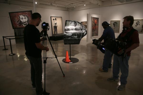 Members of the media capture footage of a piece of art titled 