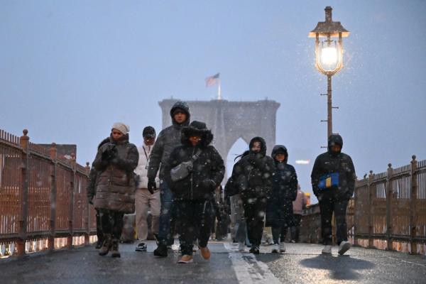 People walking in the snow on the Brooklyn Bridge during the winter storm on Jan. 6, 2023.