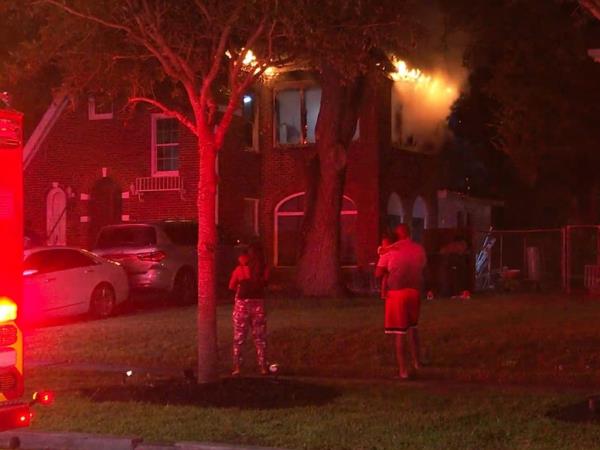 The family who now live in the home are pictured watching it on fire.