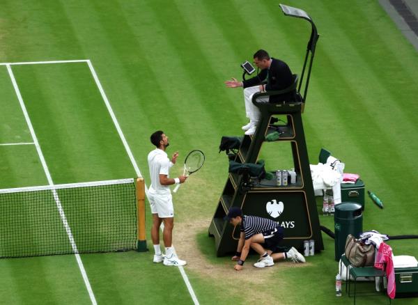 Novak Djokovic of Serbia talks to Umpire, Richard Haigh after losing a point for hindrance