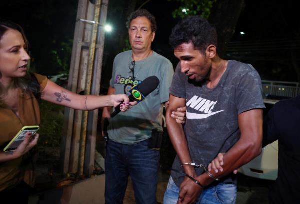 Murder suspect Alejandro Triana Prevez in handcuffs, being interviewed by reporter