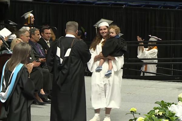 Valerie Landry walks across the stage with her son, Grayson, at Pilgrim High School's graduation ceremony on Wednesday.