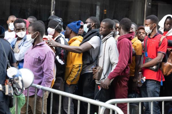 Migrant wait outside the Roosevelt Hotel shelter
