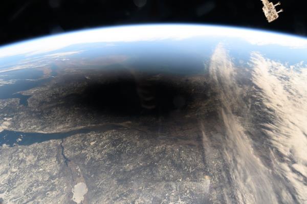 The Moon's shadow, or umbra, is pictured covering portions of the Canadian provinces of Quebec and New Brunswick and the American state of Maine in this photograph from the Internatio<em></em>nal Space Station as it soared into the solar eclipse from 261 miles above.