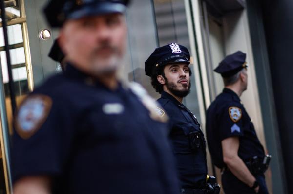 A police officer dons a beard while standing on duty.
