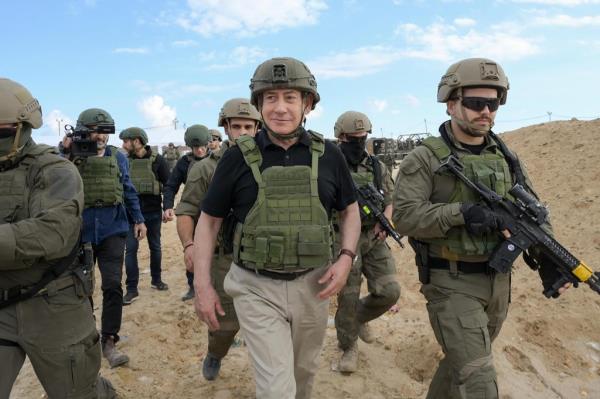 This handout picture released by the Government Press Office (GPO) shows Israeli Prime Minister Benjamin Netanyahu (C) arriving at the Netzarim Corridor, Israel's main military supply route which carves the Gaza Strip in two just south of Gaza City, on November 19, 2024. 