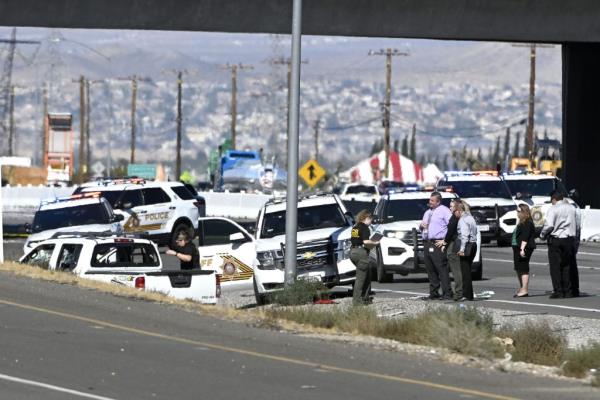Law enforcement officers and vehicles surrounding a car on a freeway in Victorville, after a shootout with murder suspect Anthony John Graziano.