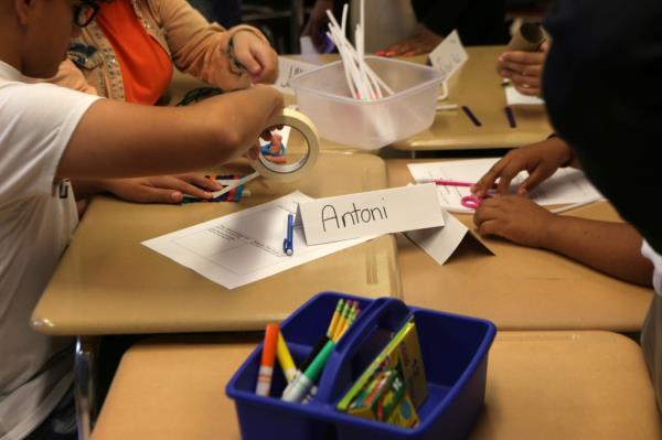 New York City Mayor Bill De Blasio visiting a dual language science class at a school in Queens, New York. Kids seen working on project over desks, name sign reading 