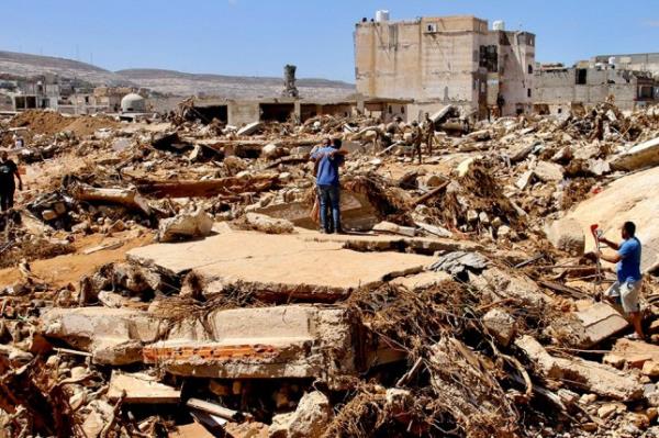 People look for survivors in Derna, Libya, Wednesday, Sept.13, 2023. Search teams are combing streets, wrecked buildings, and even the sea to look for bodies in Derna, wher<em></em>e the collapse of two dams unleashed a massive flash flood that killed thousands of people. (AP Photo/Yousef Murad)