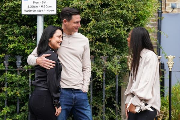 Zack with his arm round Whitney talking to Chelsea in EastEnders