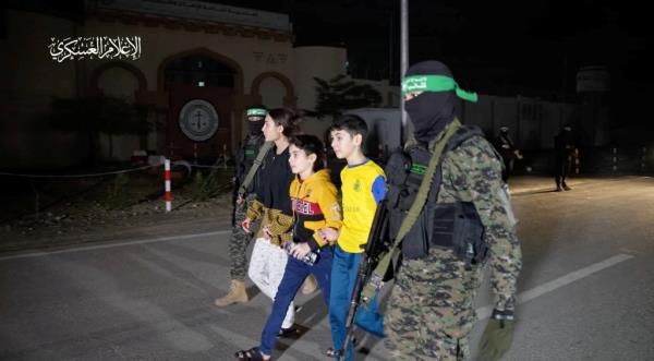 Hostages who were abducted by Hamas gunmen during the October 7 attack on Israel, are handed over by Hamas militants to members of the Internatio<em></em>nal Committee of the Red Cross on Nov. 27, 2023. 