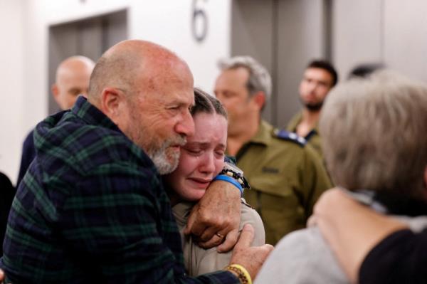 Agam Goldstein-Almog, 17, who was released from the Gaza Strip on Nov. 26 after being taken hostage by the Palestinian militant group Hamas during the October 7 attack on Israel, reacts as she is embraced by a loved one shortly after being reunited with her family. 