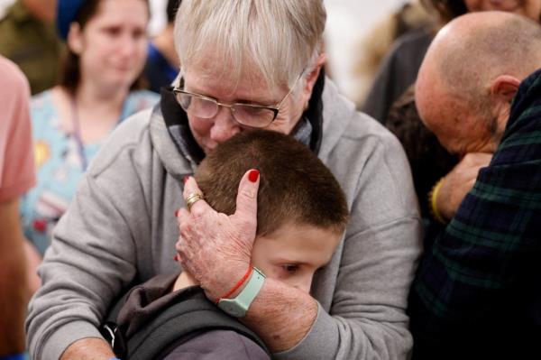 Tal Goldstein-Almog, 9, who was released from the Gaza Strip on Nov. 26 after being taken hostage by the Palestinian militant group Hamas during the October 7 attack on Israel, is embraced by a loved one shortly after being reunited with his family at Schneider Children's Medical Center of Israel in Petah Tikva. 