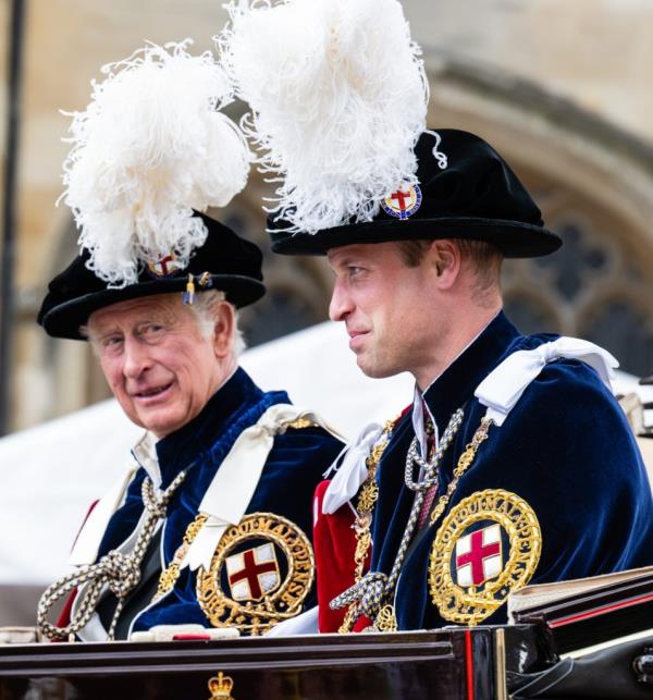 Prince Charles and Prince William attending the Order Of The Garter Service at St George's Chapel, Windsor, England, wearing regal attire with white feathers.