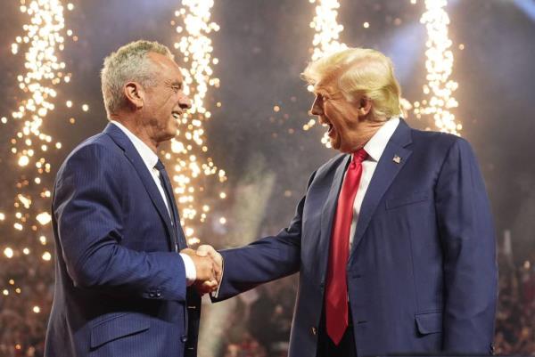 Former President Do<em></em>nald Trump shaking hands with Robert F. Kennedy Jr. at Desert Diamond Arena with fireworks in the background