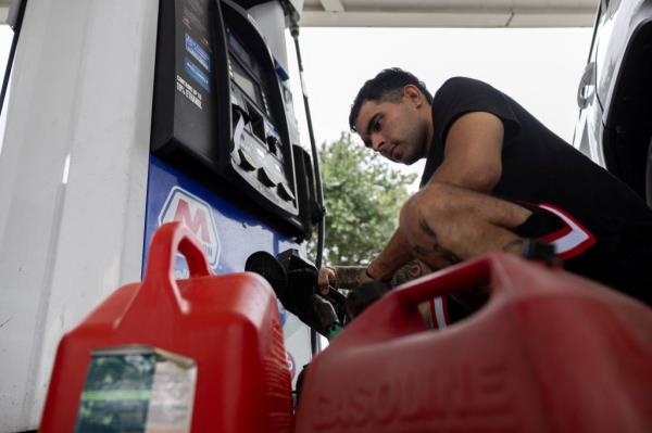 A man filling up gas co<em></em>ntainers at a station in Tampa ahead of Milton's arrival on Oct. 8, 2024.