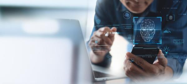 Business man scanning his face by smart phone to unlock and accessing perso<em></em>nal data.