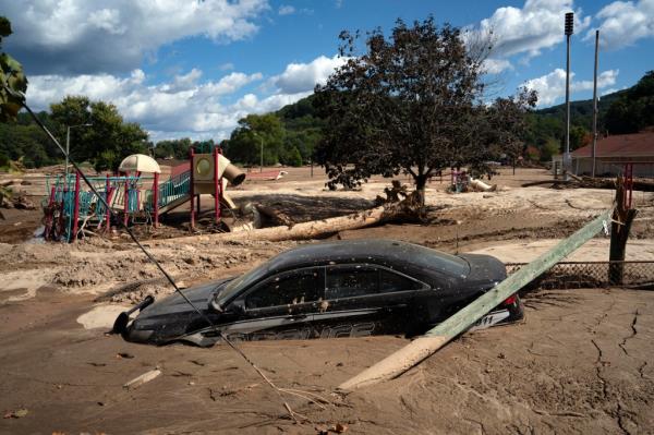 A local police car is seen half engulfed in mud, in a flooded area of Lake Lure, North Carolina, October 2, 2024.