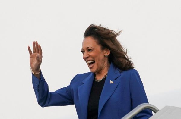 Democratic presidential candidate Kamala Harris in a blue suit waving upon arrival in Chicago for the 2024 Democratic Natio<em></em>nal Convention