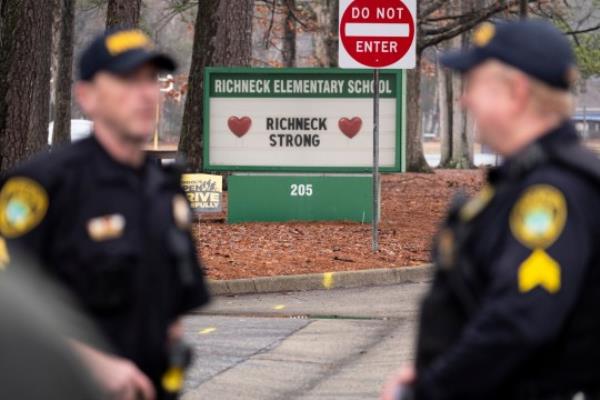 FILE - Police look on as students return to Richneck Elementary School following a school shooting in which a 6-year-old boy shot his teacher, Jan. 30, 2023, in Newport News, Va. Deja Taylor, the mother of the 6-year-old who shot his teacher at the Virginia elementary school, is expected to be sentenced Friday, Oct. 27, for felony child neglect, 10 mo<em></em>nths after her son used her handgun to critically wound the educator. (Billy Schuerman/The Virginian-Pilot via AP, File)