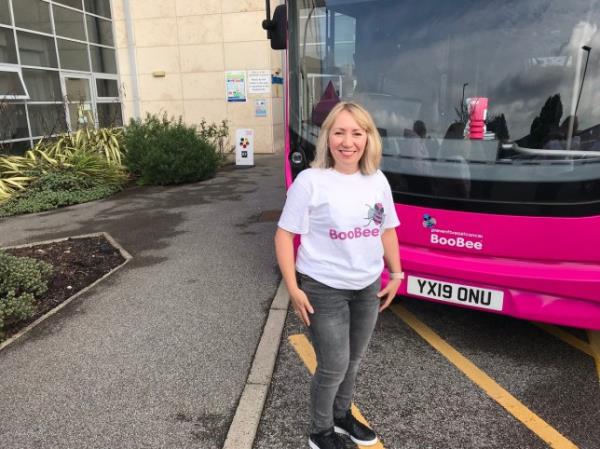 Kirsty standing in front of a pink bus with 'BooBee' written on her t-shirt
