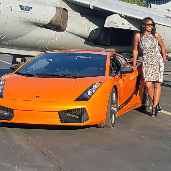 Tanya Smith alo<em></em>ngside an orange sports car