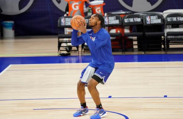 Bro<em></em>nny James in blue jersey holding a basketball at the 2024 NBA Draft Combine in Chicago