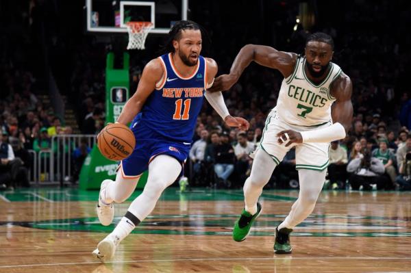 New York Knicks guard Jalen Brunson co<em></em>ntrolling the ball while Boston Celtics guard Jaylen Brown defends during a game at TD Garden.