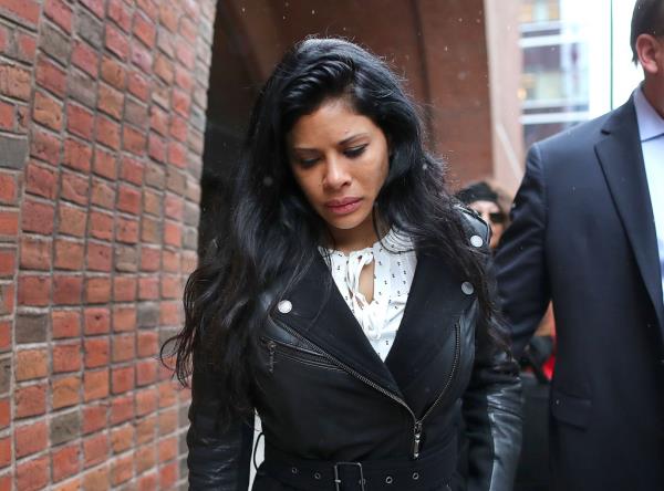 Sunrise Lee outside of court wearing a black leather jacket and a white shirt looking down. 