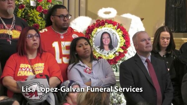 Crowds at funeral for Lisa Lopez-Galvan. People wearing Chiefs jerseys in church. Group of flowers in front of mourners.