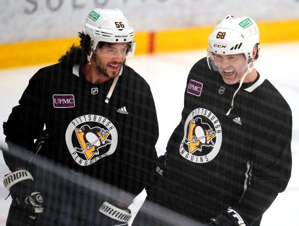 Pittsburgh Penguins' Kris Letang, left, wearing a mullet wig, shares a laugh with former teammate Jaromir Jagr during NHL hockey practice, Saturday, Feb. 17, 2024