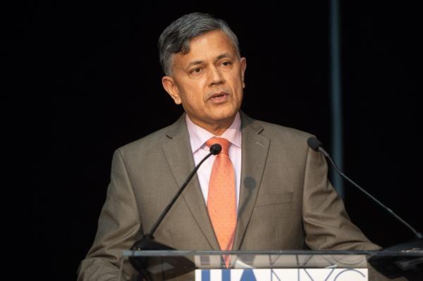 Vijay Dandapani in a suit and tie standing at a podium with micropho<em></em>nes during the Hotel Association Of New York City Foundation's Annual Red Carpet Hospitality Gala