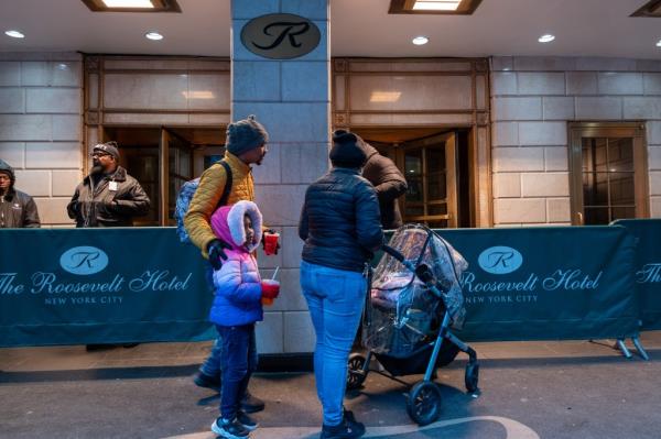 Migrant families checking into a processing center at the Roosevelt Hotel in midtown Manhattan during winter