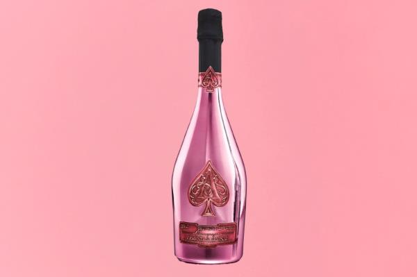 A pink champagne bottle with a black cap on a Gift Guide cover