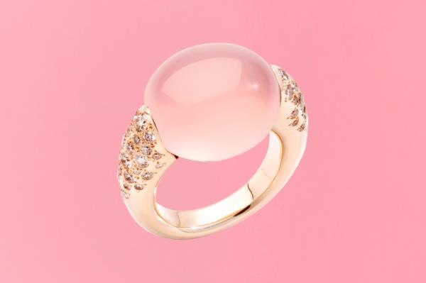 A gold ring with a pink stone and diamo<em></em>nds on a gift guide cover